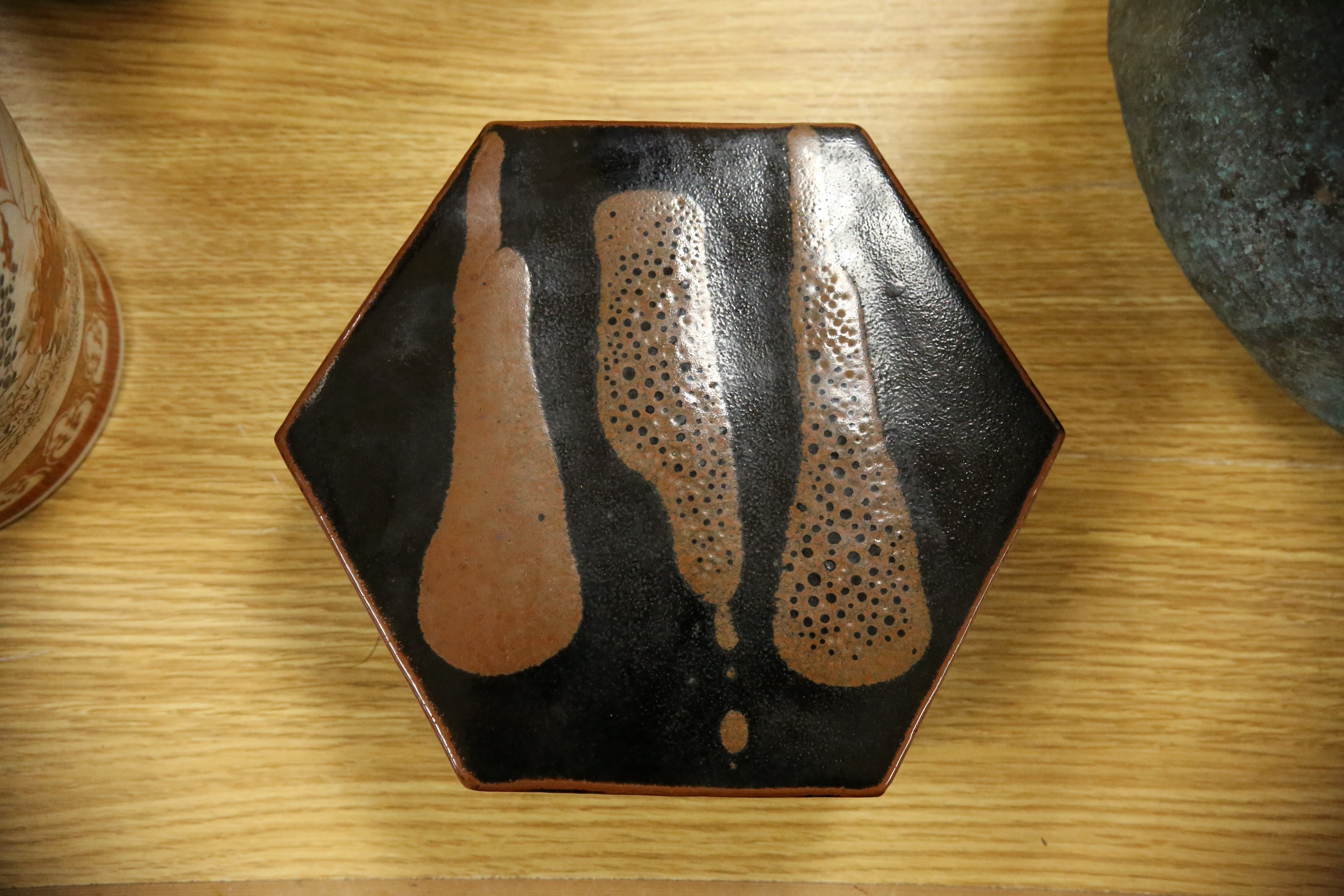 A Japanese studio tenmoku glazed hexagonal box and cover, unmarked, 18cm wide. Condition - good